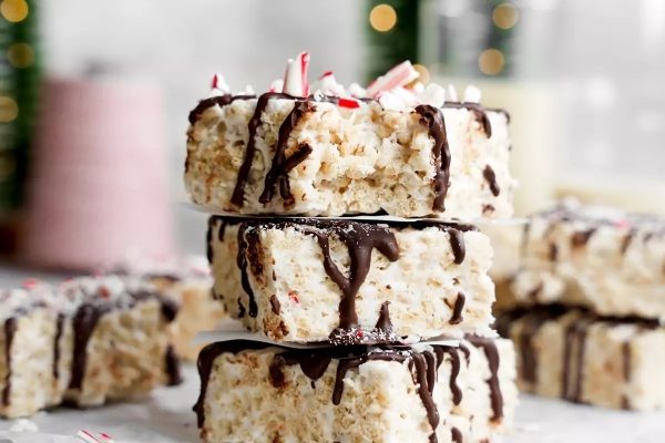 A stack of rice krispy treats with chocolate and peppermint drizzle.