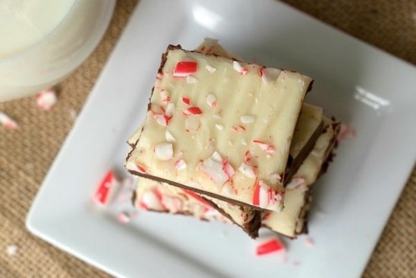 A plate of peppermint chocolate fudge with a glass of milk.