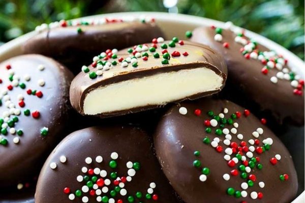 A bowl of chocolate covered cookies with sprinkles.