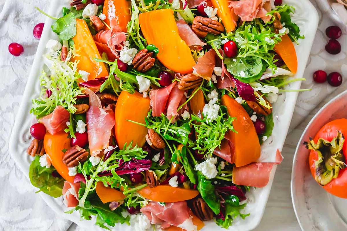 A salad with cranberries, pecans, and arugula.