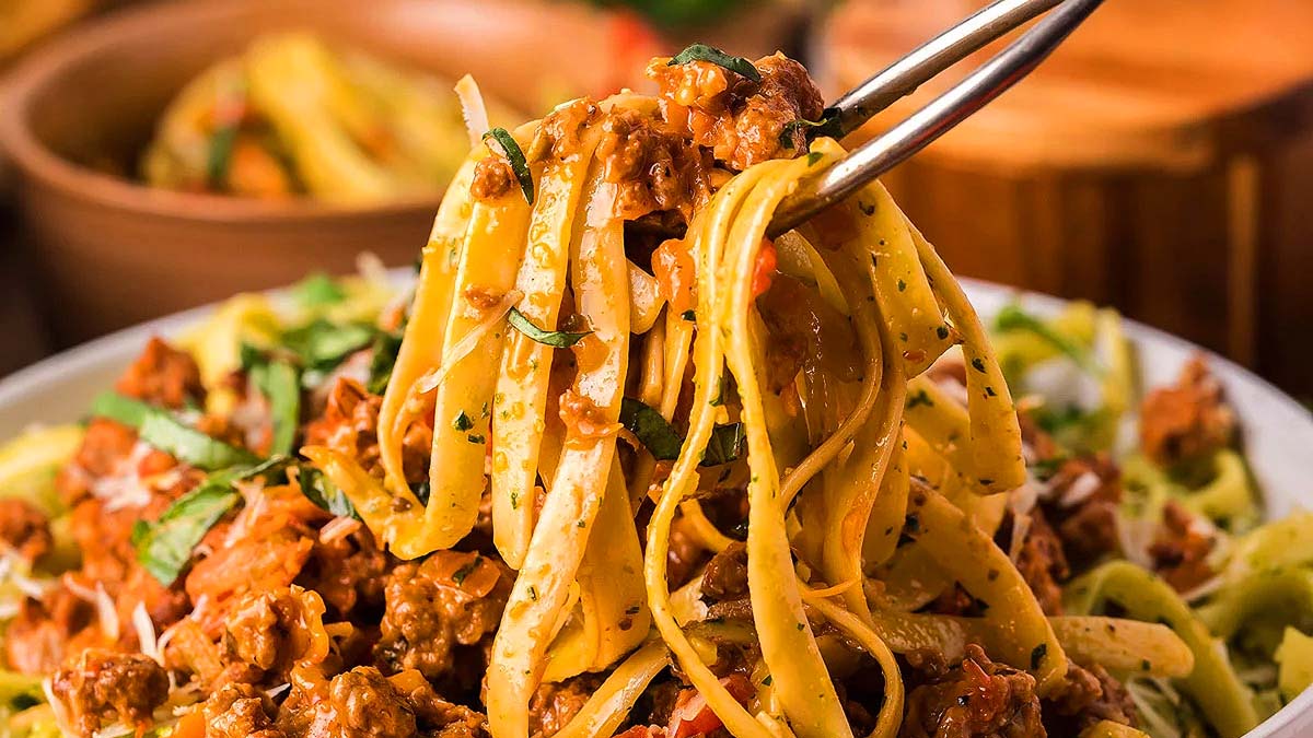 Pasta being scooped form a bowl.
