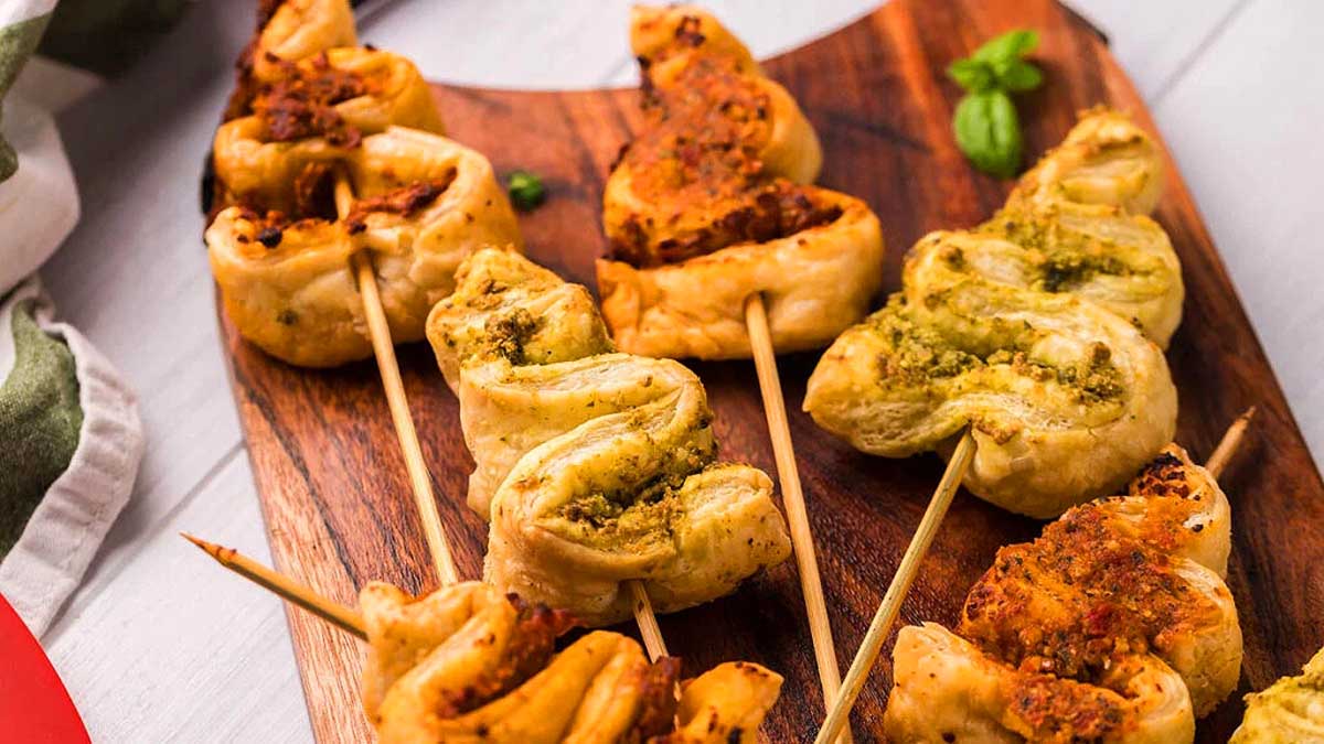 A wooden cutting board with skewers of meat on it, perfect for creating delicious puff pastry recipes.
