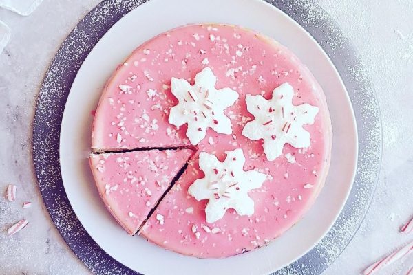 A pink cake with candy canes on top.
