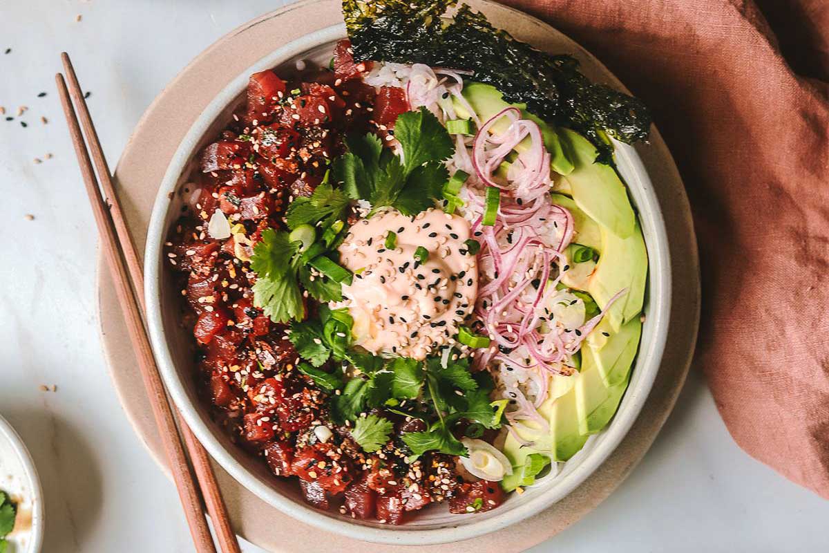 A bowl of food with chopsticks.