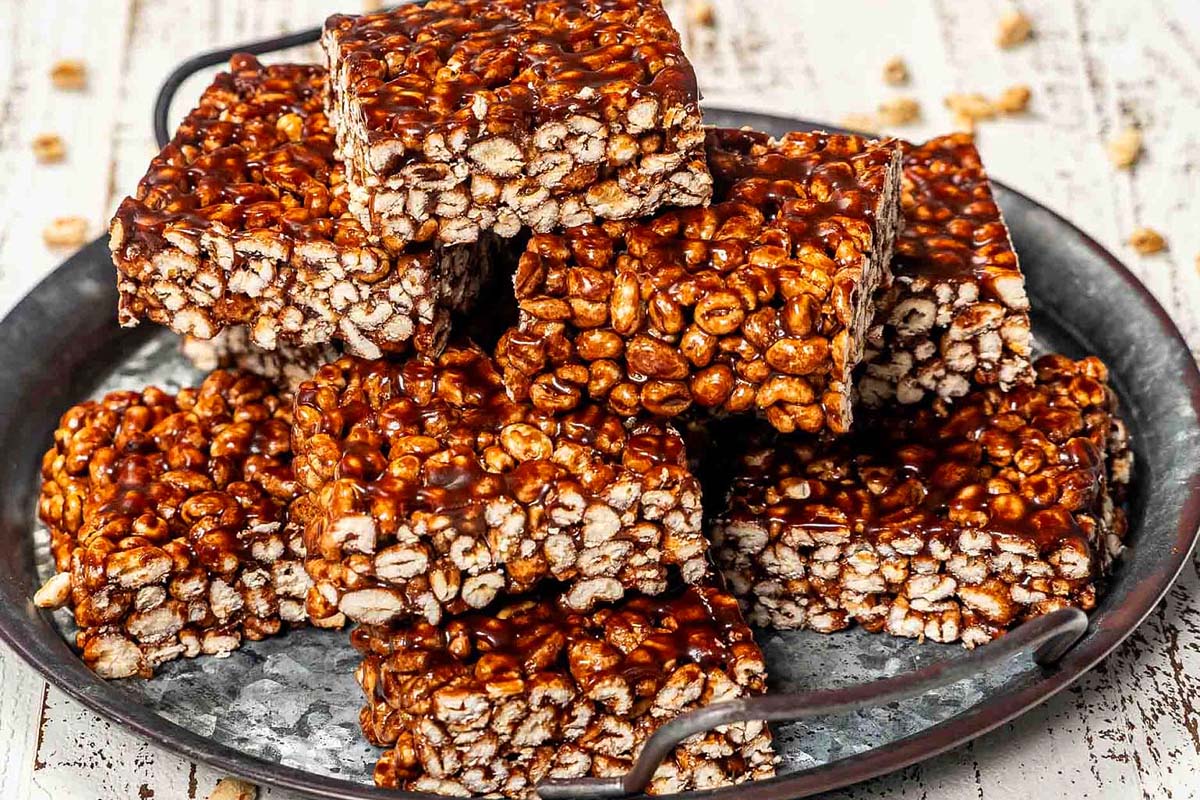 A plate of raisin bars on a wooden table.