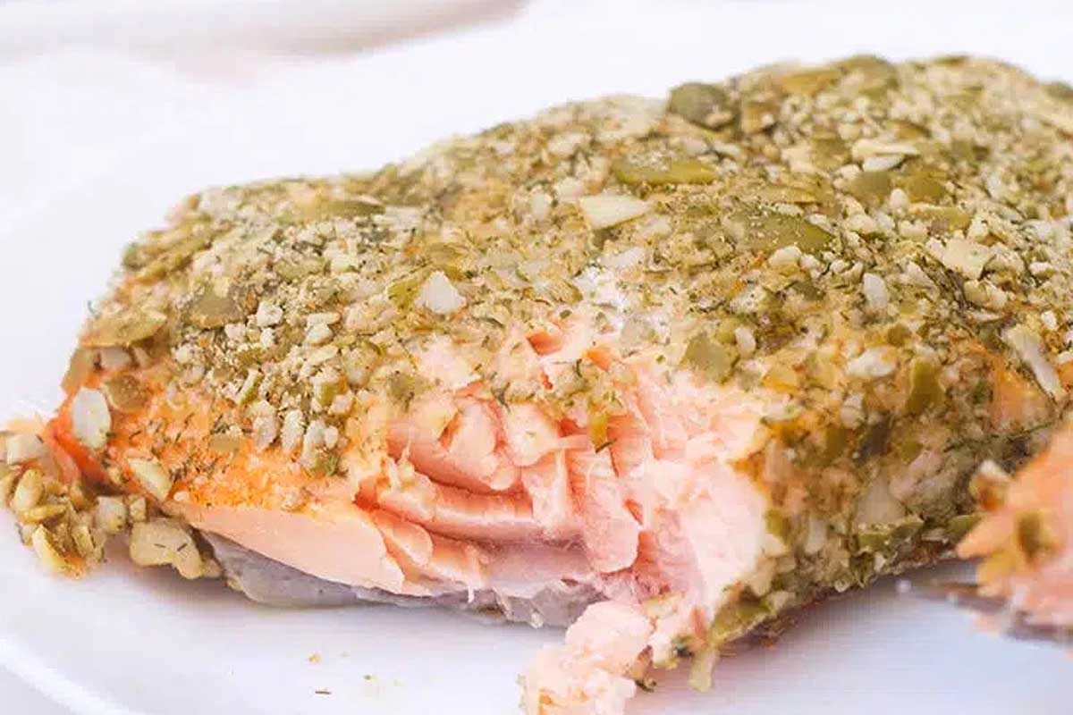 A piece of salmon on a white plate.