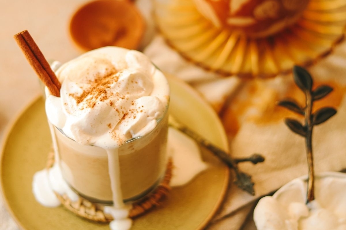Pumpkin spice latte with whipped cream and a cinnamon stick. 
