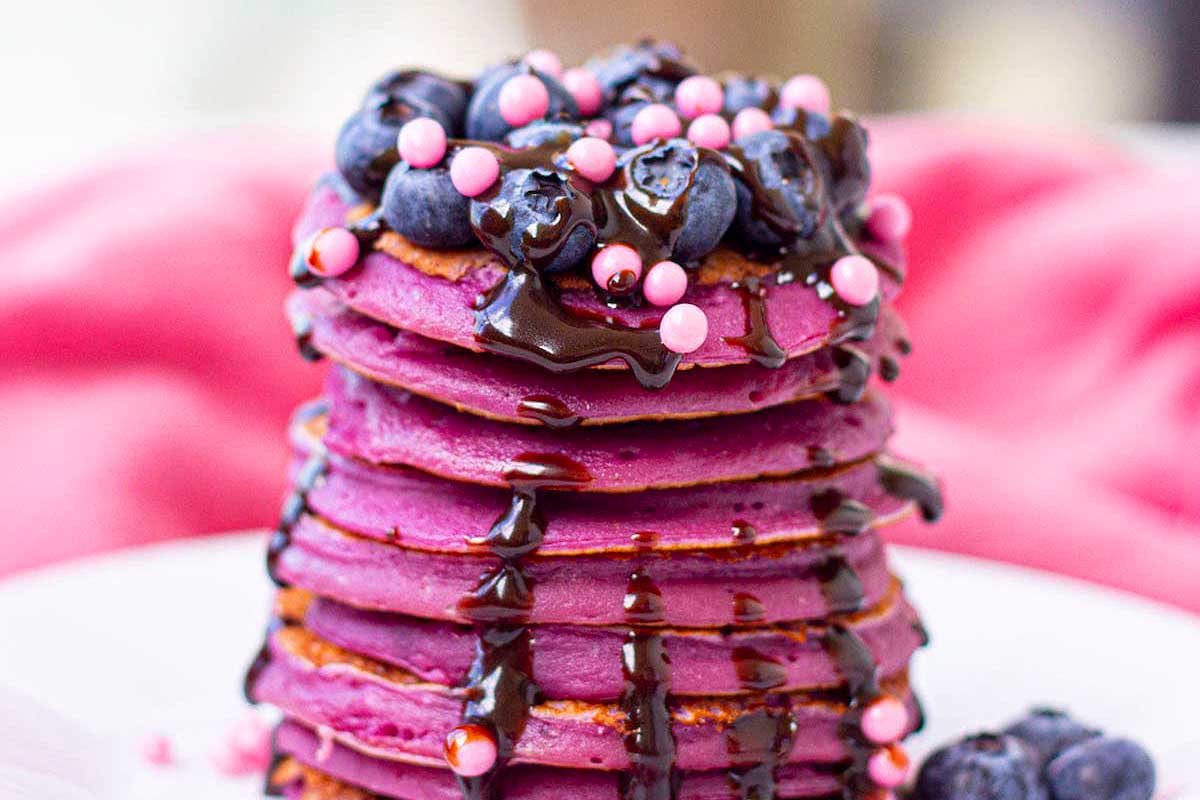 A stack of delicious brunch pancakes topped with chocolate and blueberries.