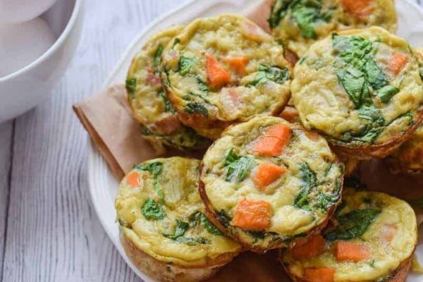 Quiche muffins with spinach and carrots on a plate.
