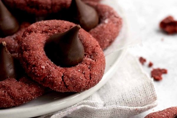 Red velvet cookies with chocolate kisses on a plate.