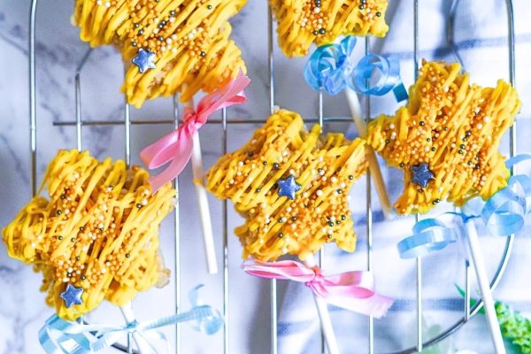A group of yellow star shaped cookies on a cooling rack.