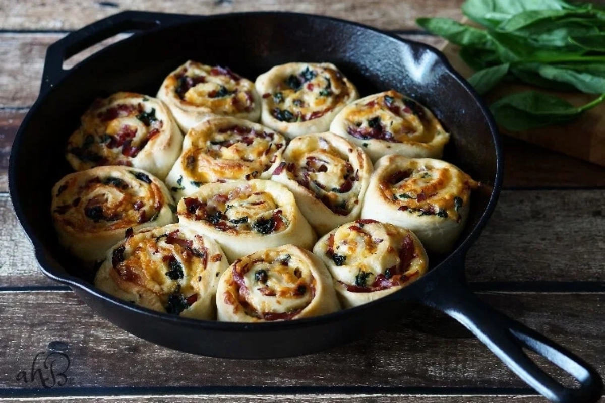 Festive cranberry spinach rolls perfect for New Year's Eve appetizers, served in a skillet on a rustic wooden table.