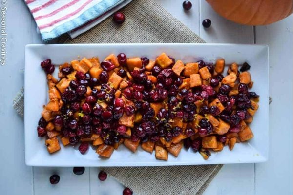 Cranberries and sweet potatoes, perfect for Thanksgiving, served on a white plate.