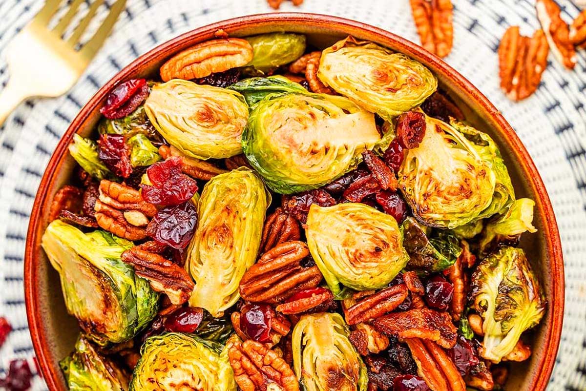Brussels sprouts with cranberries and pecans in a bowl. This is one of the best ham side dish recipes.