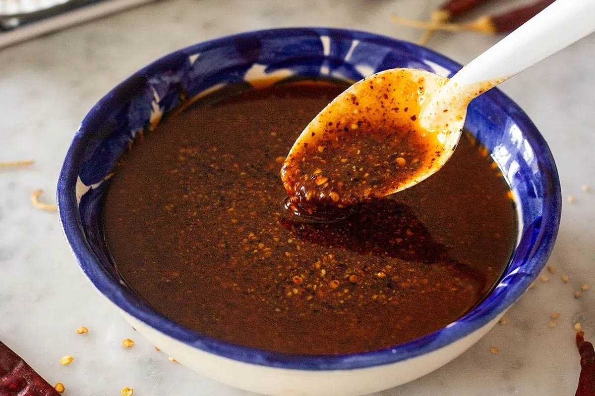 A spoonful of sauce in a blue bowl.