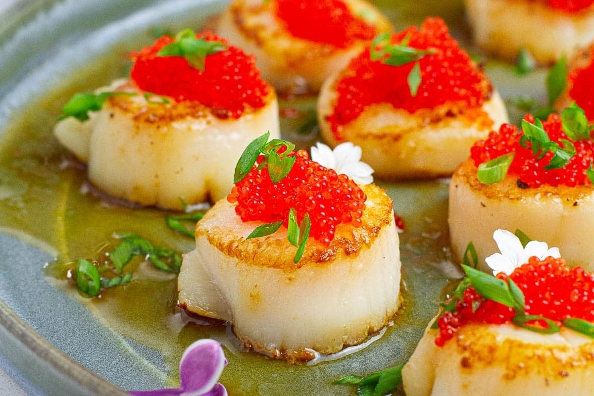 Appetizers for New Year's Eve: Scallops with caviar on a plate.