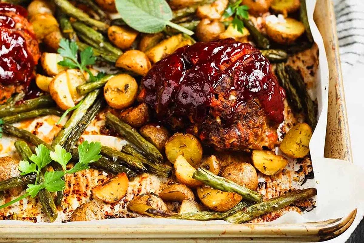 A baking sheet with meatballs and green beans, perfect for quick and easy meatloaf recipes.