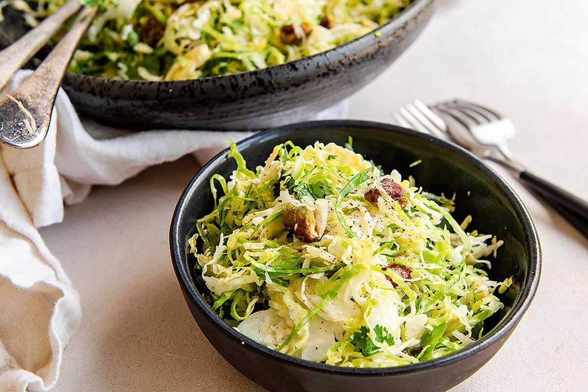 A bowl of brussels sprout salad with walnuts.