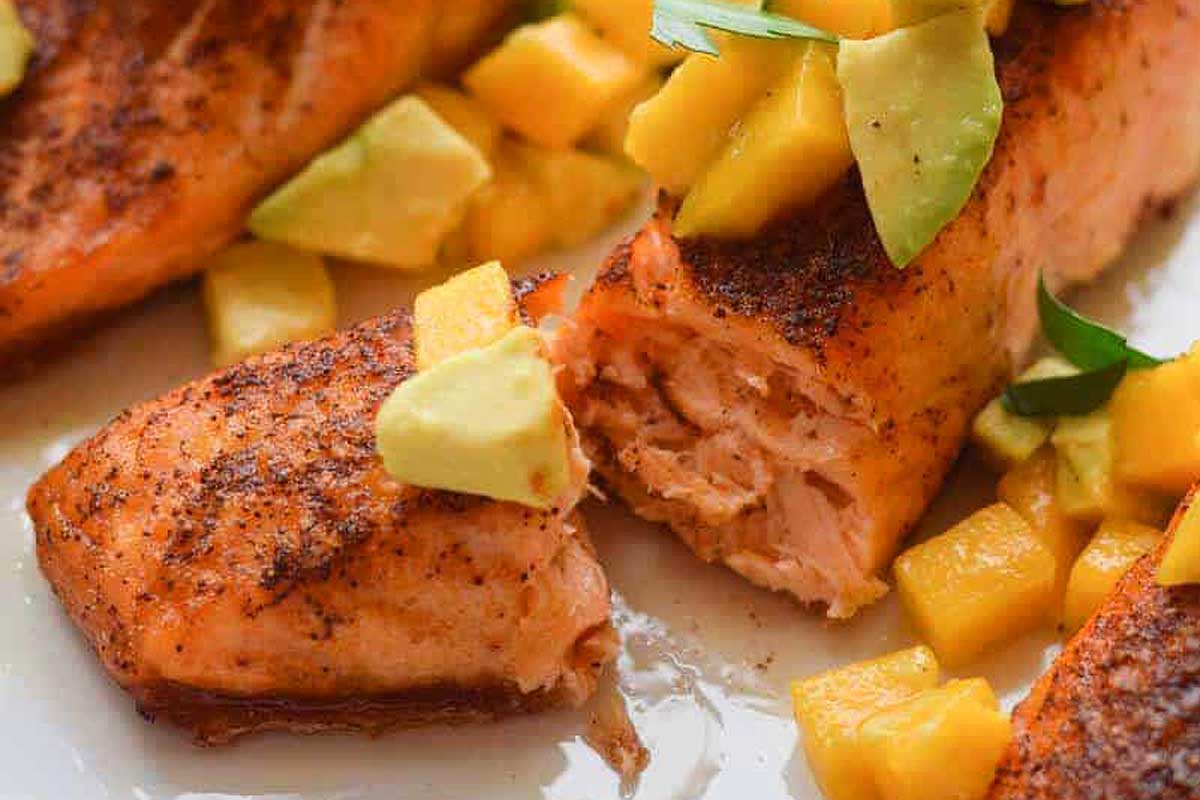 Salmon with mango and avocado on a plate.