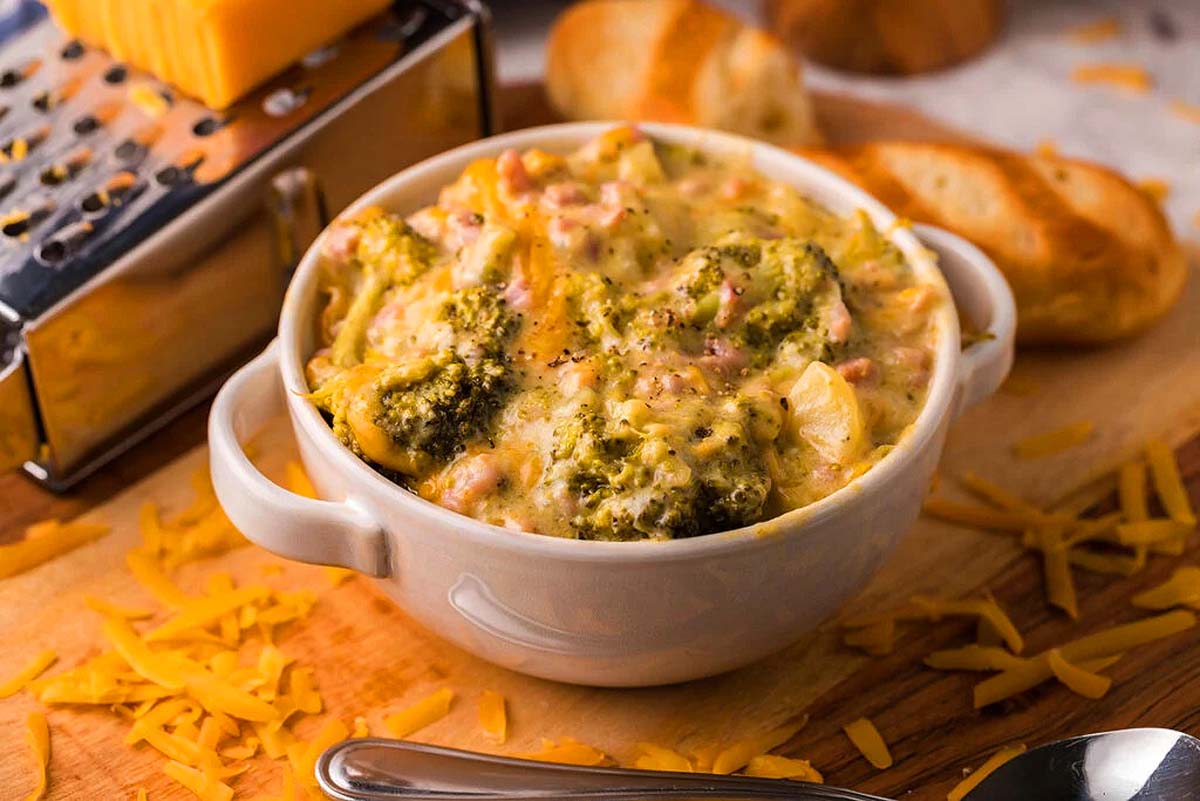 A bowl of broccoli and cheese soup with a cheese grater. This is one of the best Campbell's soup recipes using a can of soup.