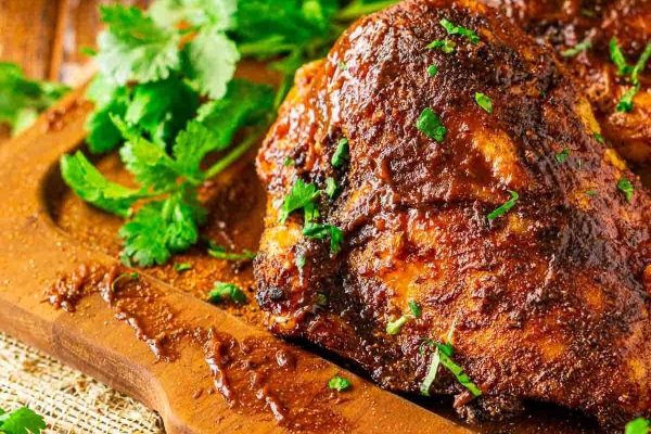 Bone-in chicken breasts on a wooden cutting board.