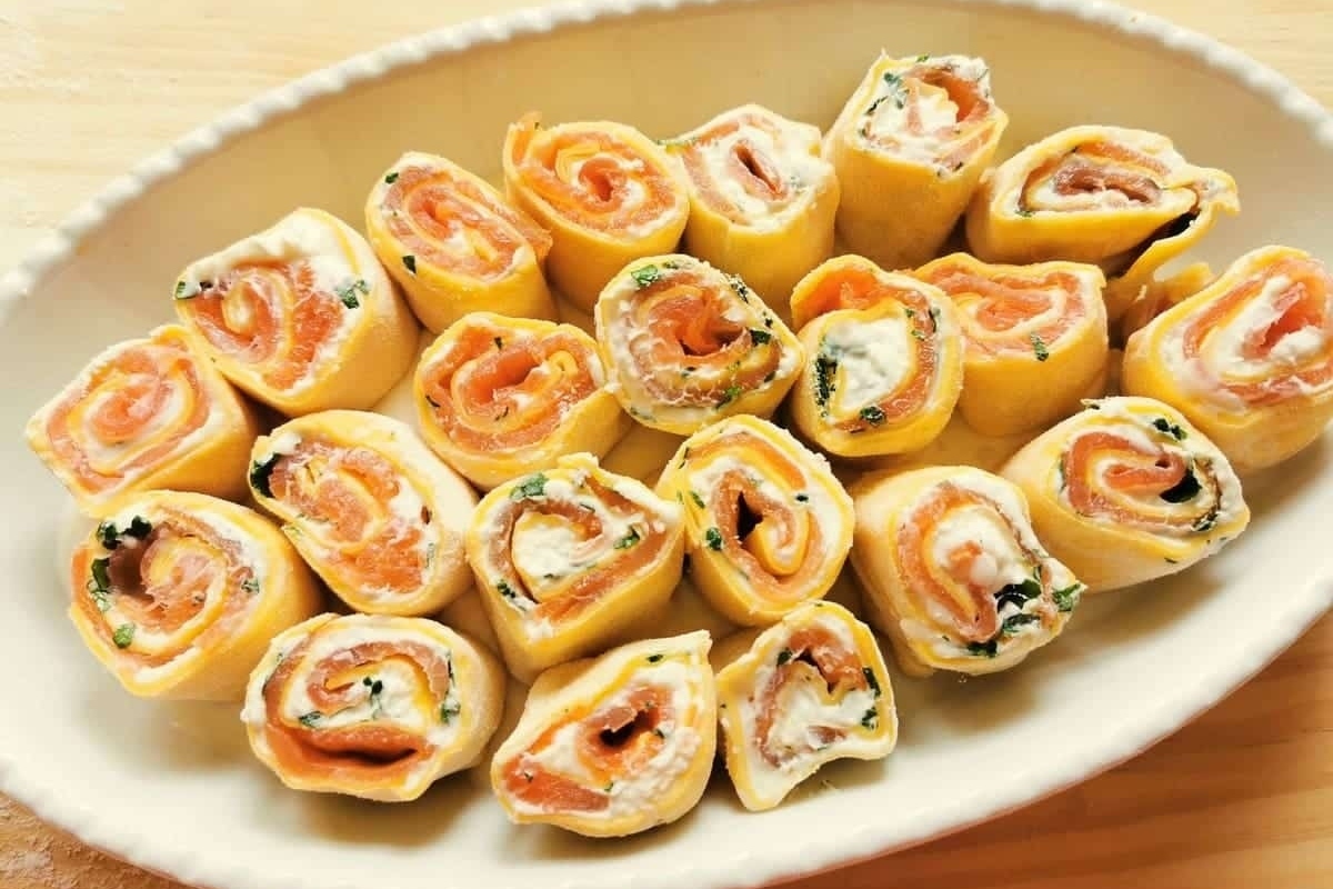 Salmon roll ups on a white plate, perfect for salmon dinners.