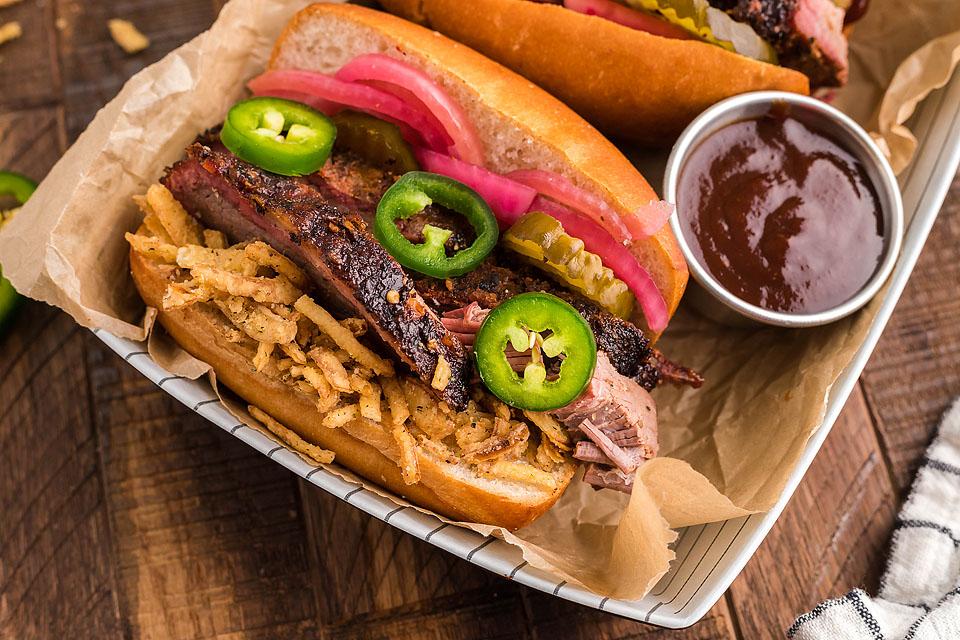 Bbq pulled pork sandwich served on a bun, topped with bbq sauce.