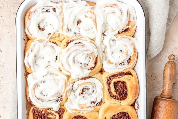 Cinnamon rolls in a baking dish with icing.