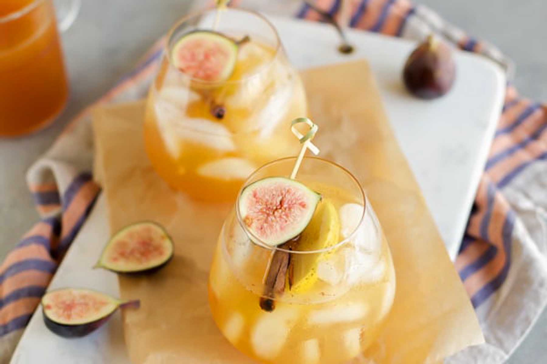 Two glasses of sangria with figs and ice.