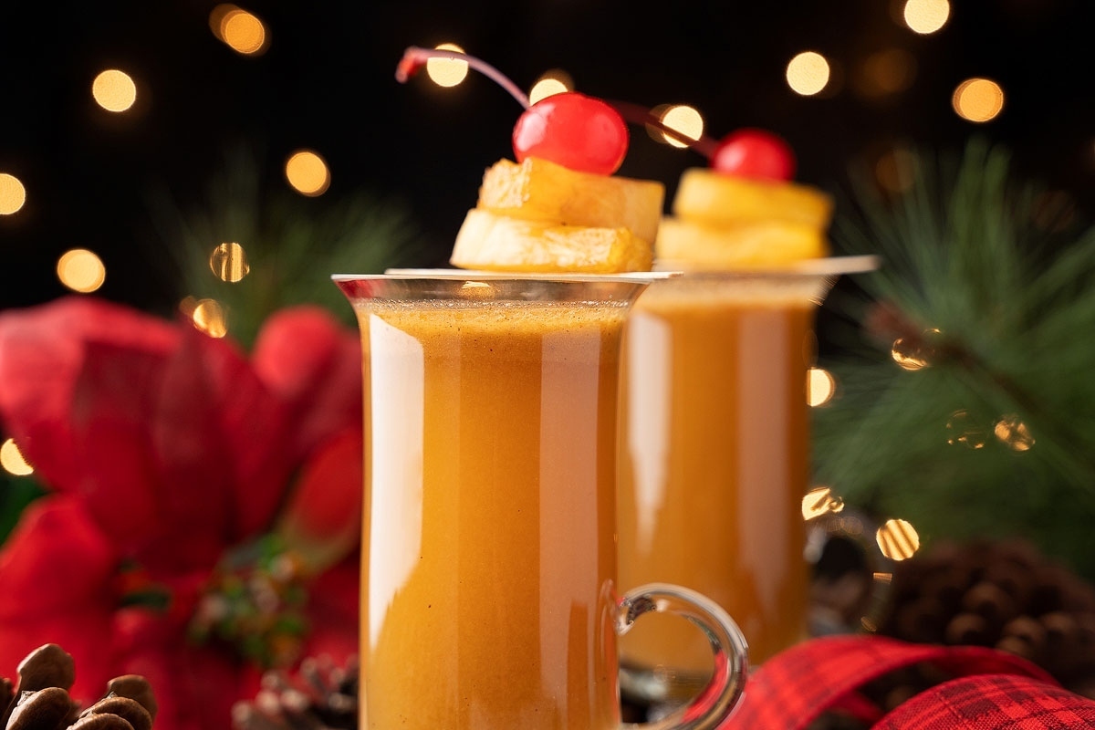 Two glasses of mulled wine with cherries and pine cones, perfect for Thanksgiving.