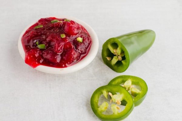A potluck dish of cranberry jalapeno sauce with spicy jalapeno peppers, perfect for Thanksgiving.