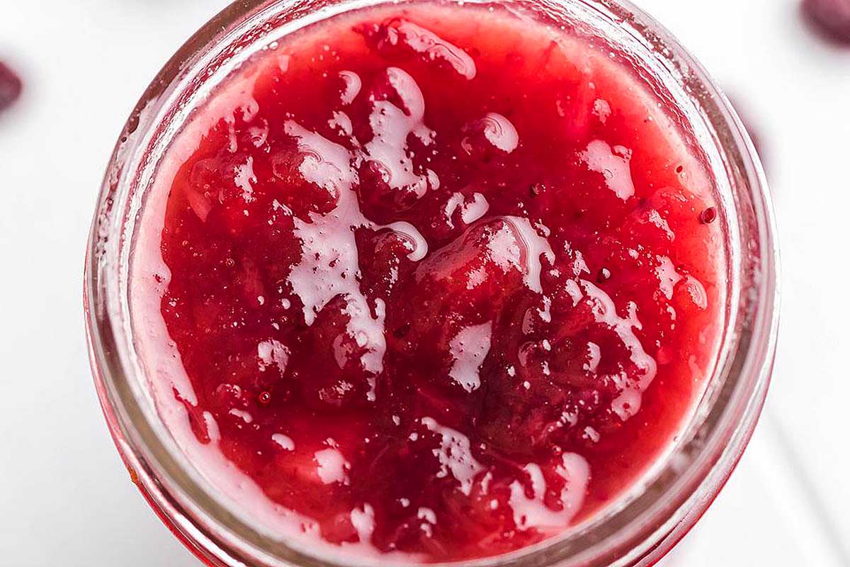 Glass jar of cranberry sauce.