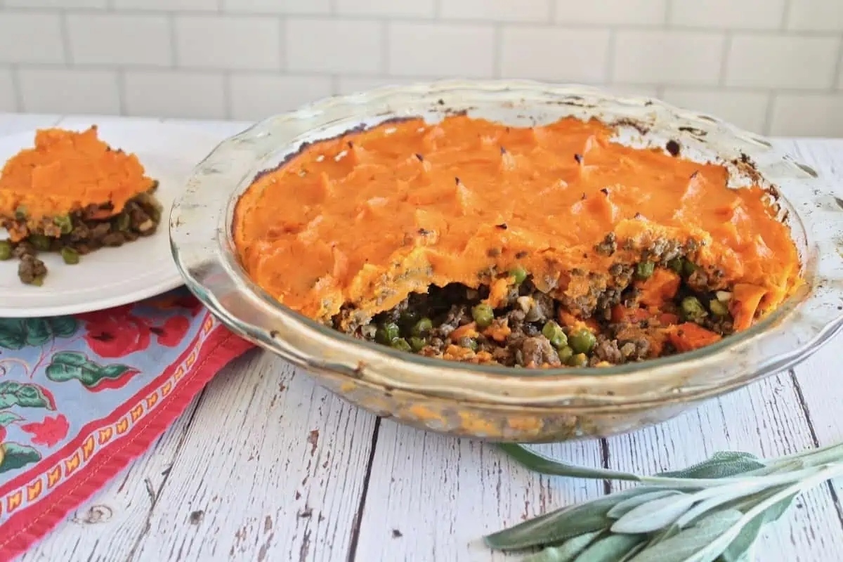 A comforting dinner dish featuring a slice of pie topped with fragrant sprigs of sage, perfect for winter indulgence.
