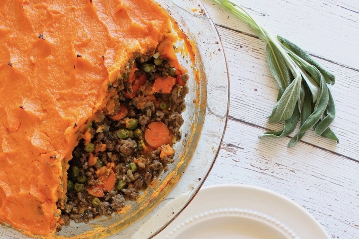 A Thanksgiving pie with carrots and sprigs on a plate.