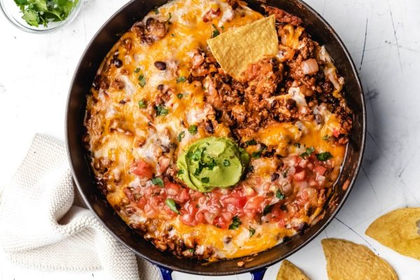 Delicious Mexican dip made in a skillet with tortilla chips, perfect for using pantry staples. Serve with homemade guacamole for extra flavor.
