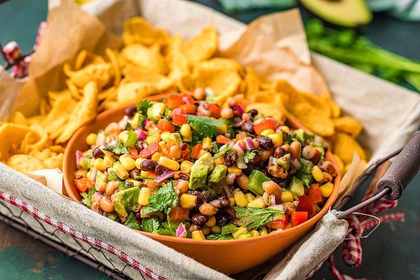 A bowl of black bean and corn salsa with tortilla chips.