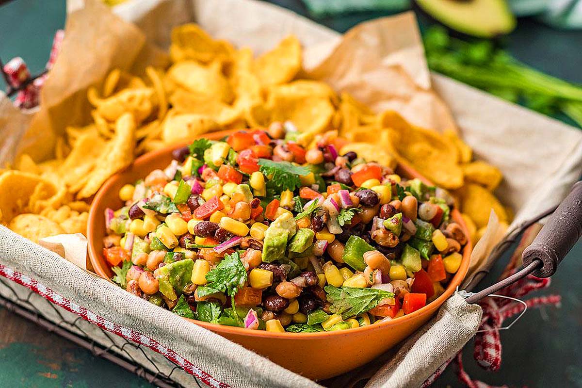 A bowl of black bean and corn salsa with tortilla chips.