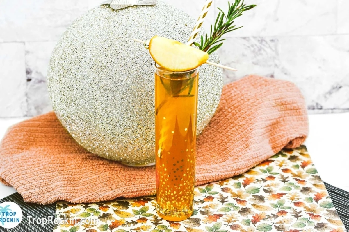 A Thanksgiving cocktail featuring a glass of apple cider with a rosemary sprig.