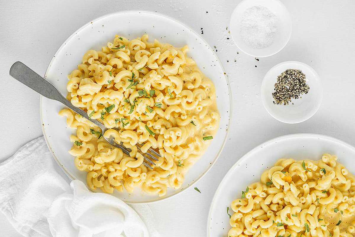 Two plates of macaroni and cheese on a white background, perfect for an Instant Pot Thanksgiving feast.