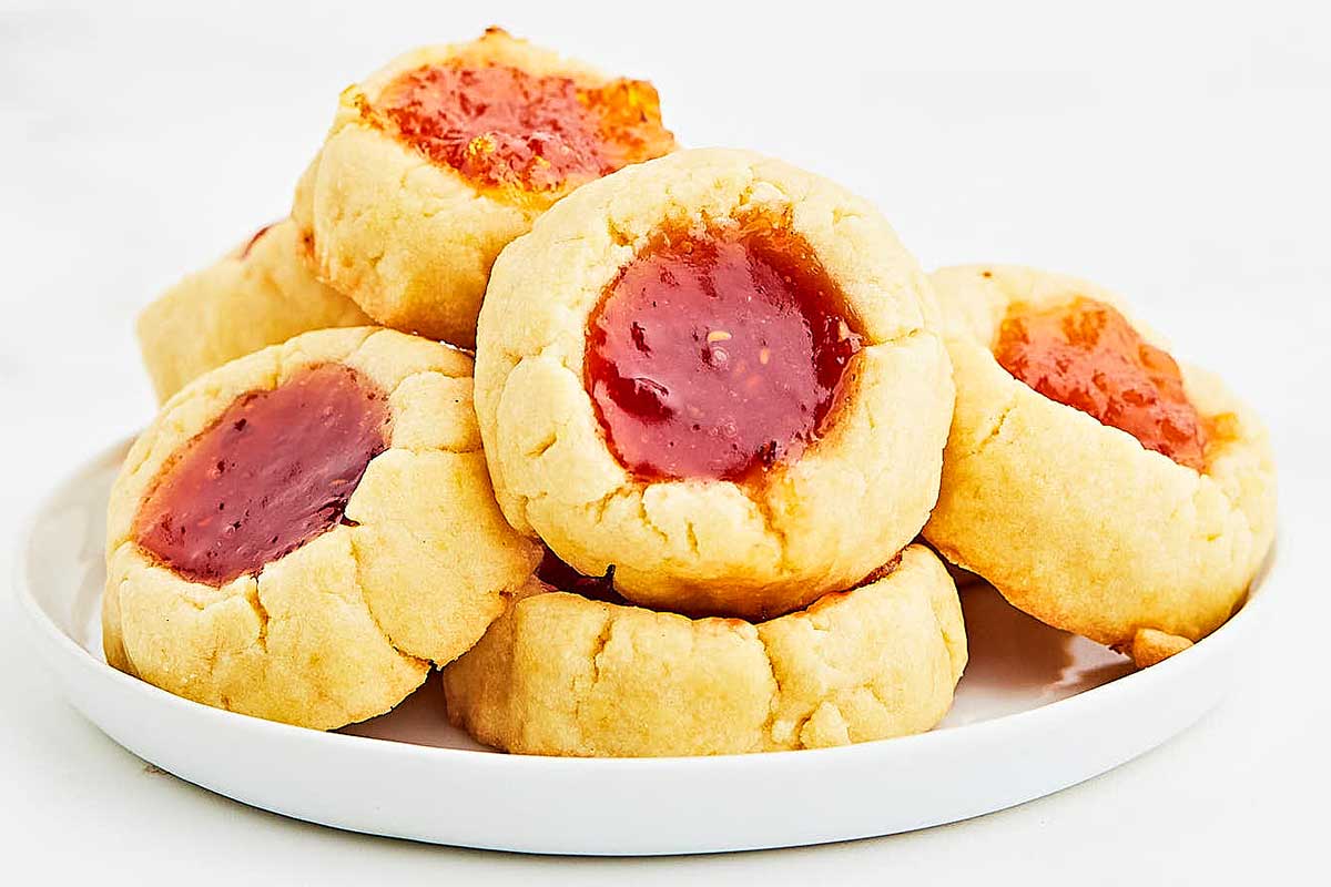 Jam centered bite sized cookies on a plate.