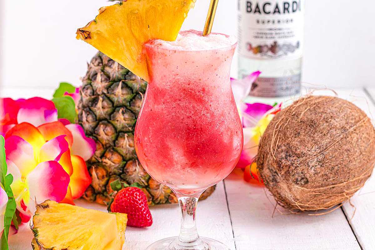 A Hawaiian-inspired cocktail with strawberries, pineapples, and a bottle of bourbon.