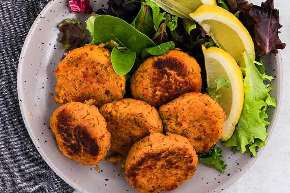 A plate of food with lemons and greens.