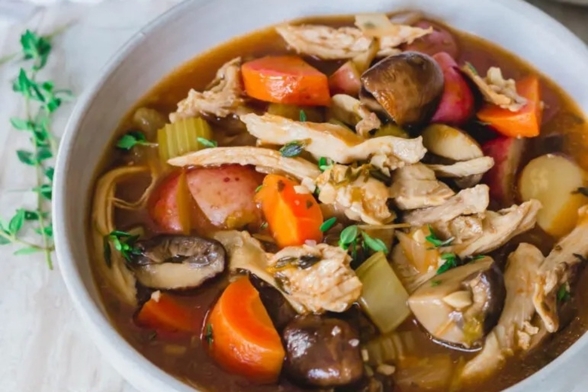 A bowl of chicken stew with vegetables and herbs, perfect for using up leftover turkey in delicious recipes.