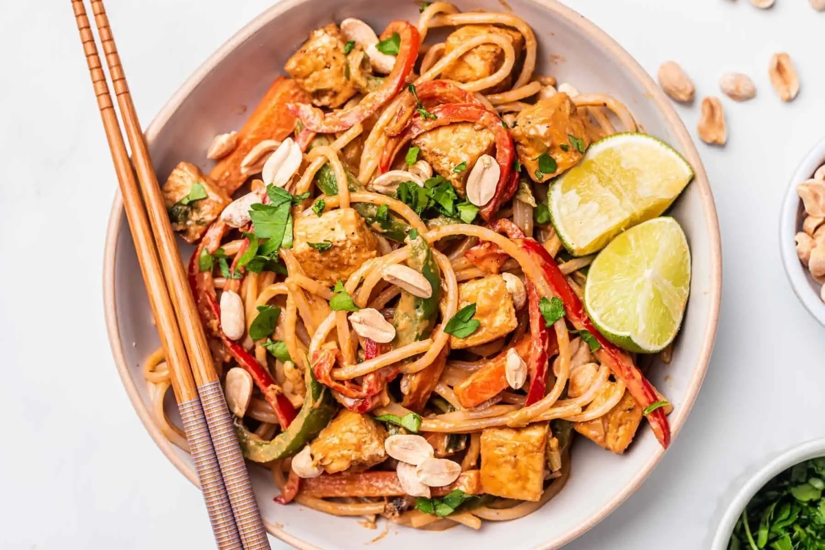 Thai tofu noodles in a bowl with chopsticks.