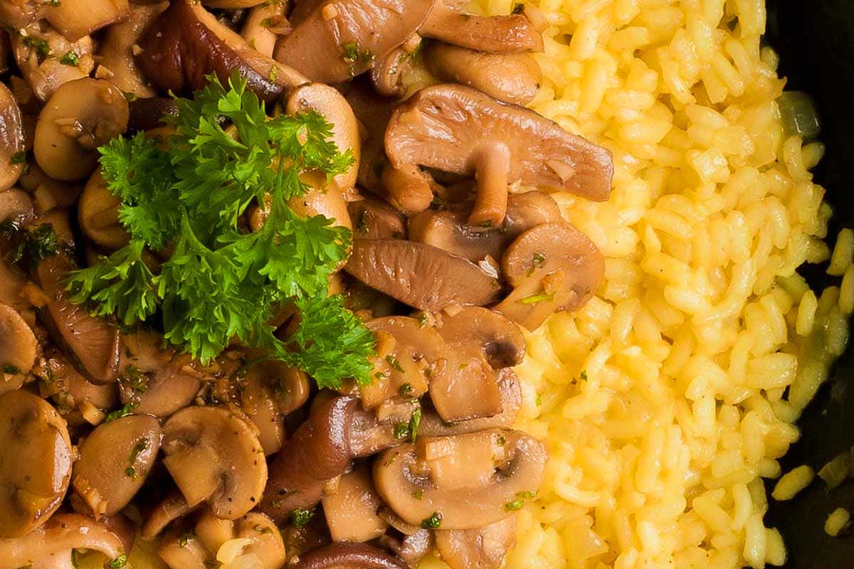 A delectable combination of mushrooms and rice cooked to perfection in a skillet, garnished with fresh parsley. Ideal for a cozy date night.
