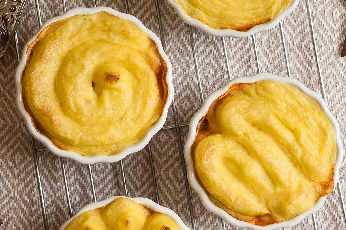 A stack of vegan mini pumpkin pies on a cooling rack, perfect for Thanksgiving.