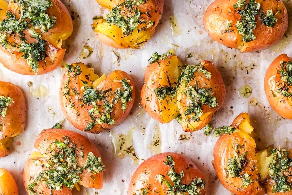 Roasted tomatoes with pesto on a baking sheet.