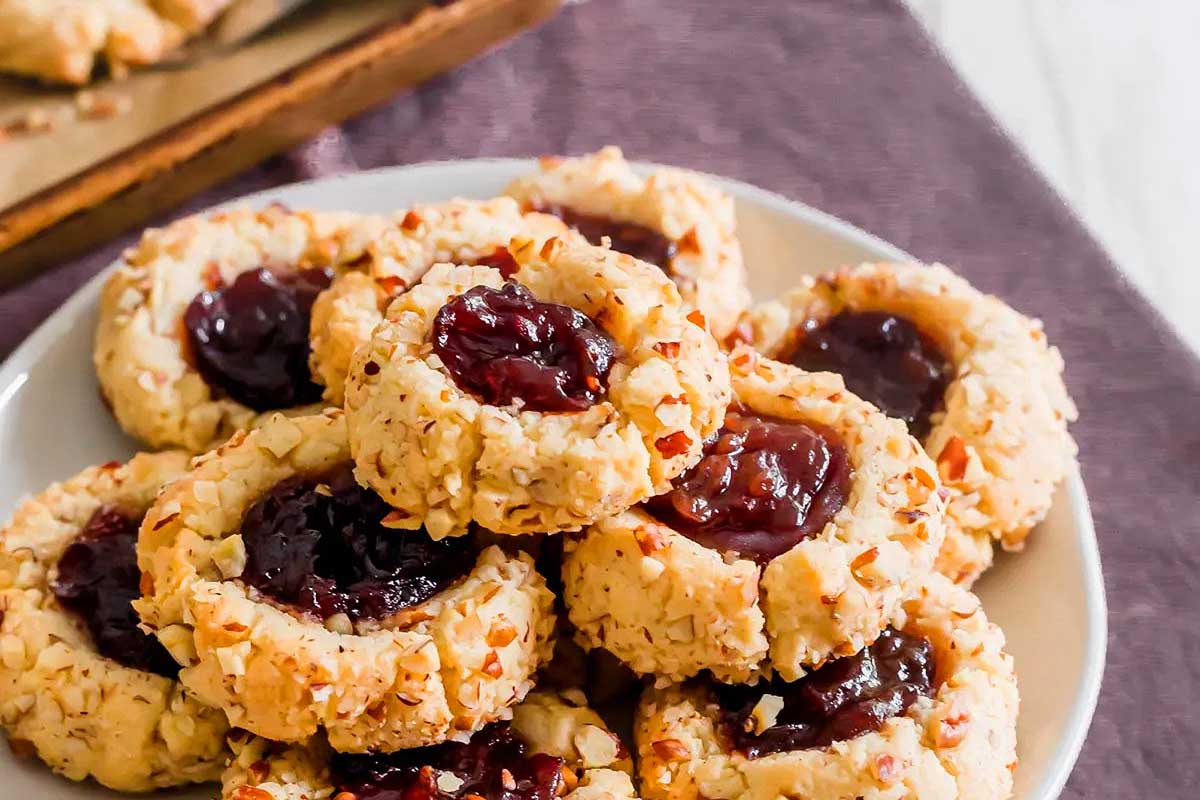 Thumbprint cookies stacked on a plate.