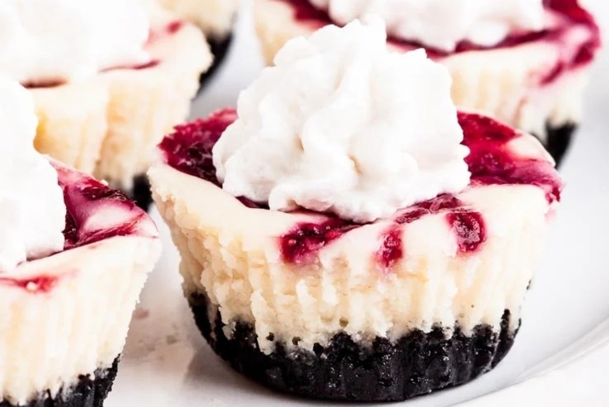 Christmas-themed blackberry cheesecake bites on a white plate.