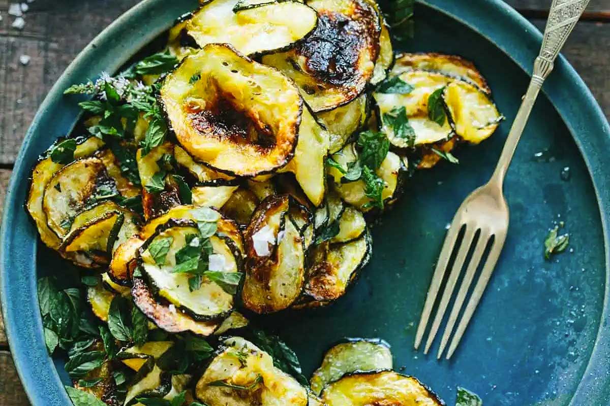 A plate of grilled zucchini on a wooden table.